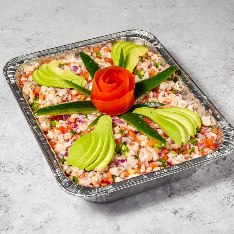 Jalisco Taqueria's shrimp ceviche in a foil tray, garnished with avocado slices and a tomato rose.